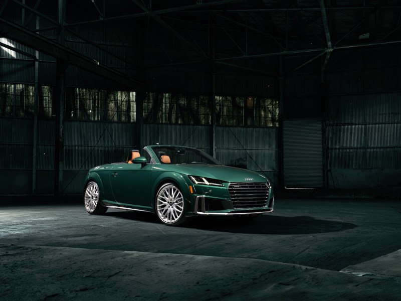 2023 Audi TT Roadster Final Edition right front three-quarter view of the green car with the top down in an empty warehouse