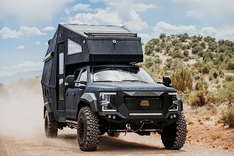 27North F550 Ascender overlander truck camper driving down a dirt road.