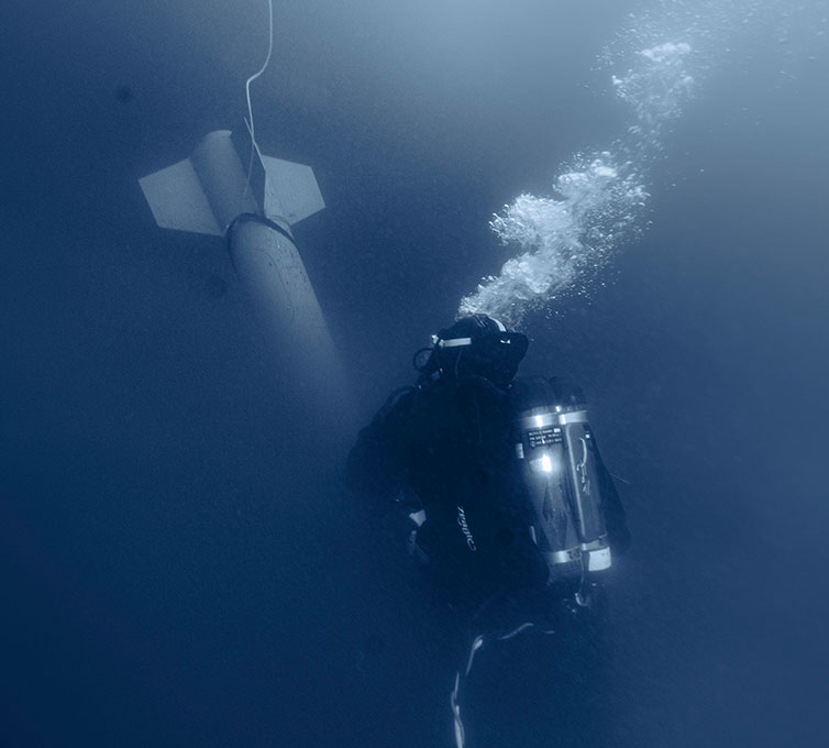 US Navy diver disarming a torpedo