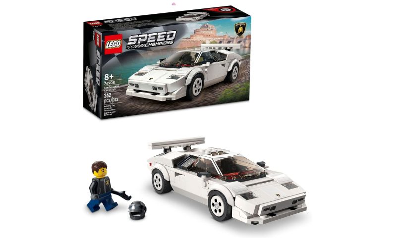 A Lego Lamborghini Countach with associated driver in front of its box.