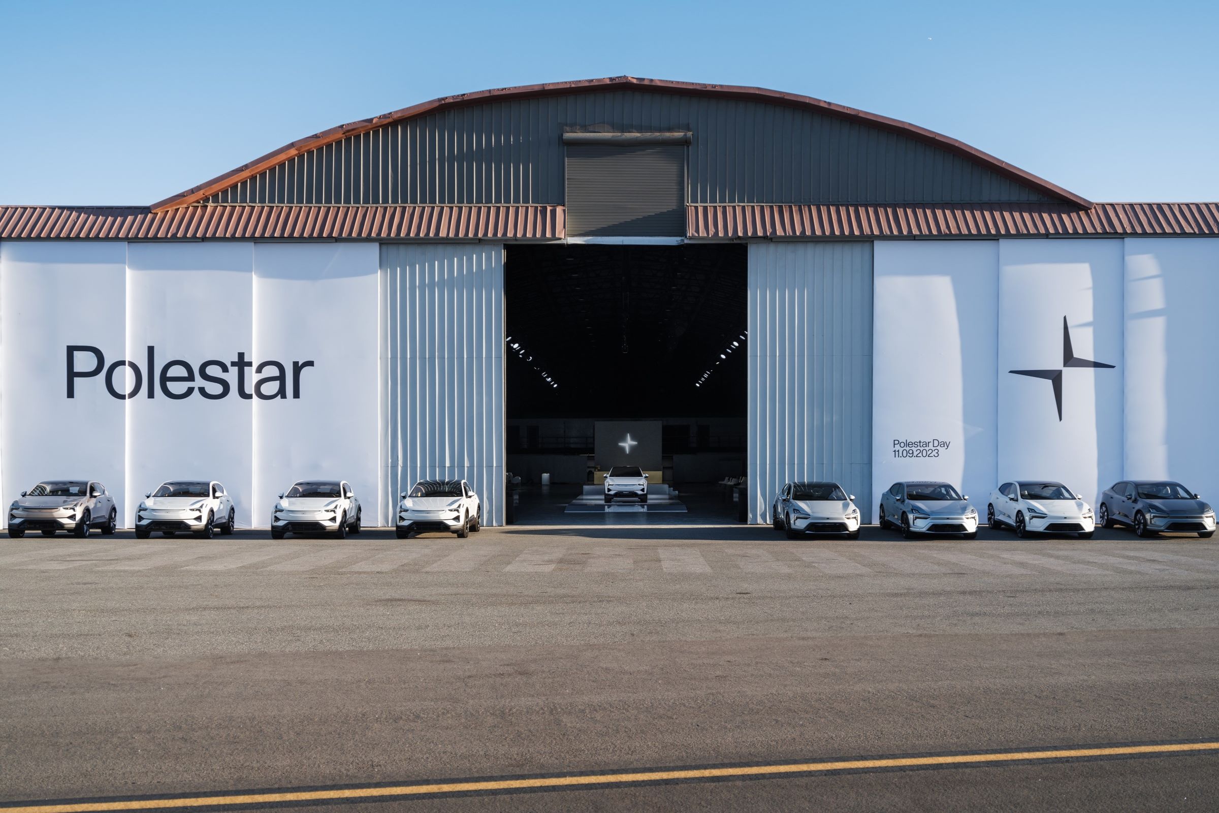 Polestar EVs parked outside of a warehouse.