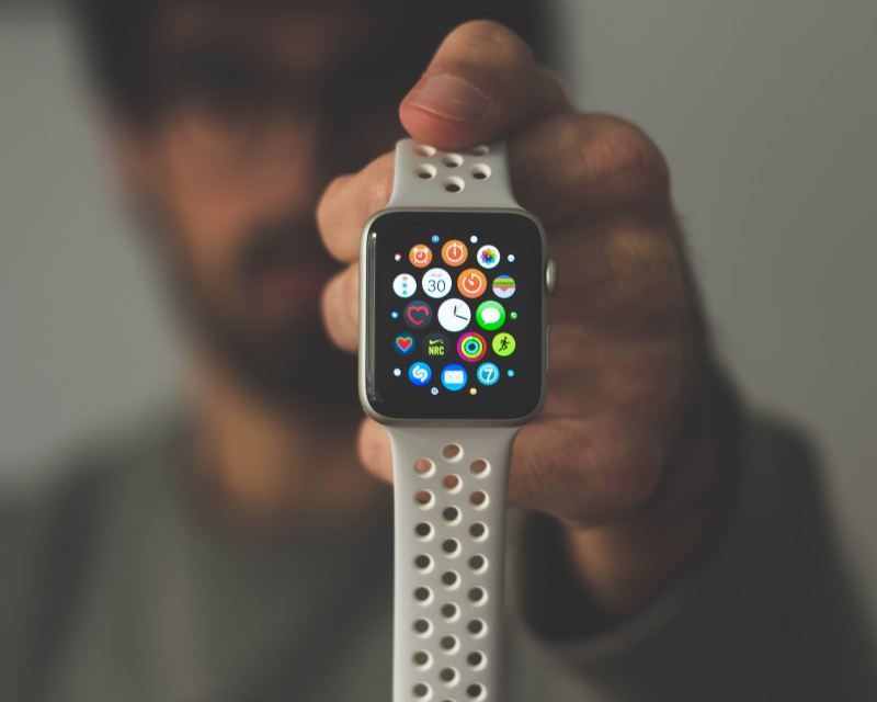 A person holding up an Apple Watch.