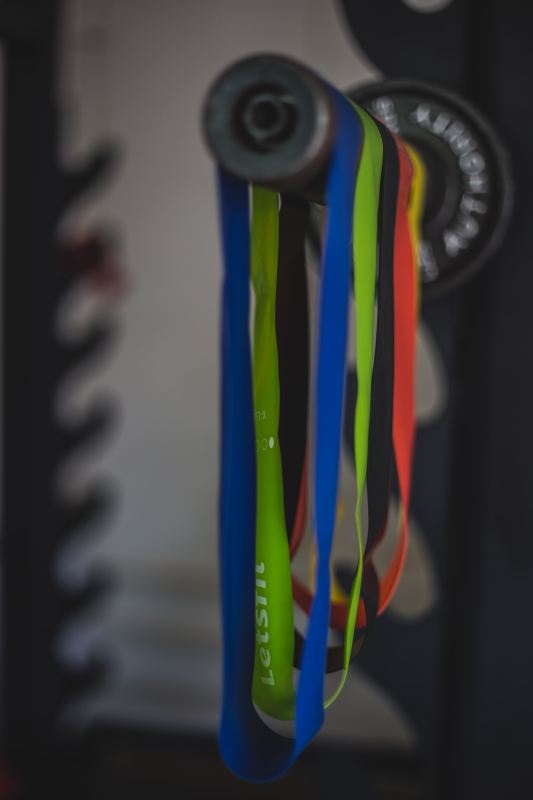 Colorful gym resistance bands hanging on weights in gym