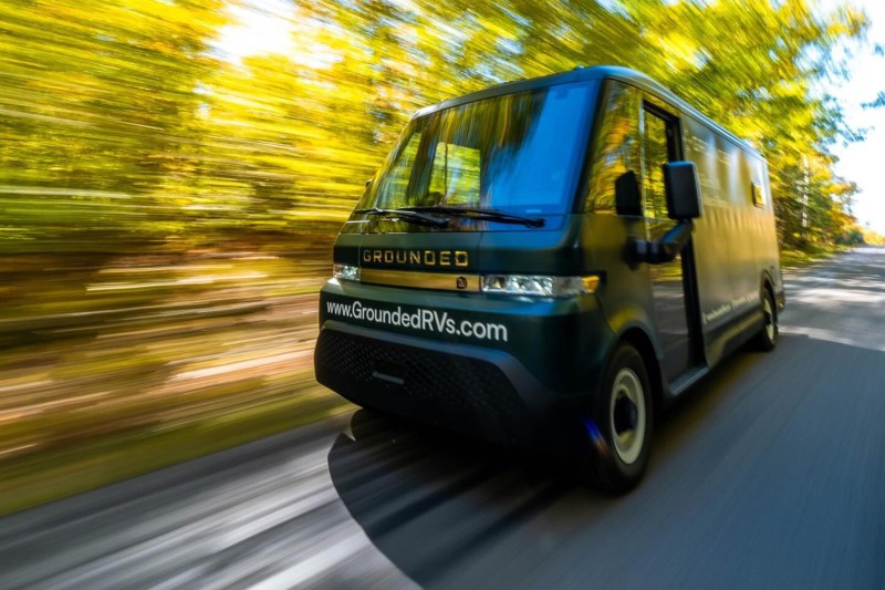 Blurred view of the Grounded RVs G2 electric RV camper van driving down a country road.