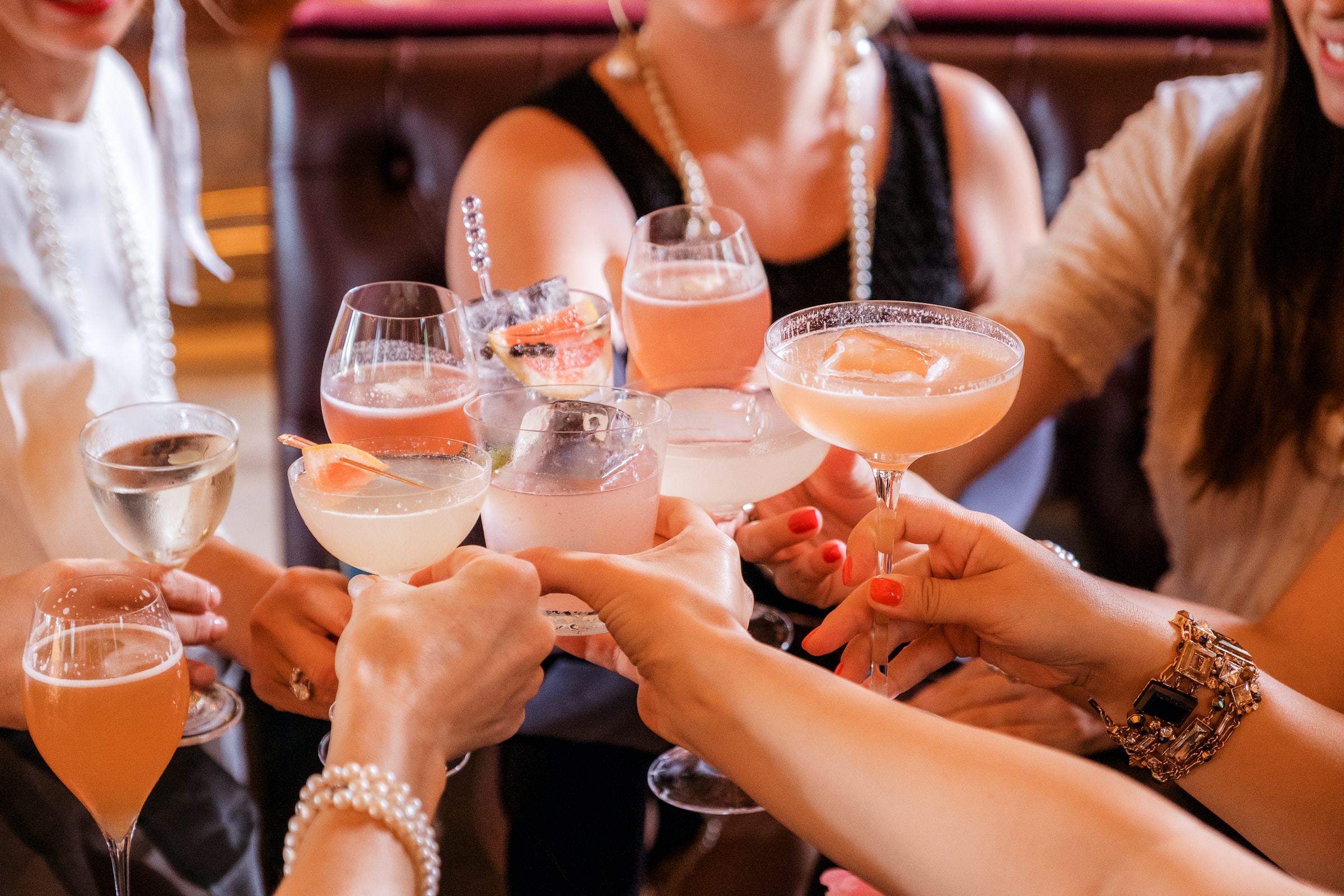 Crowd of people toasting with cocktails