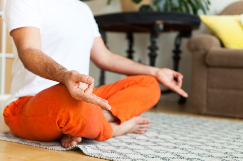 Man practicing yoga and meditation at home