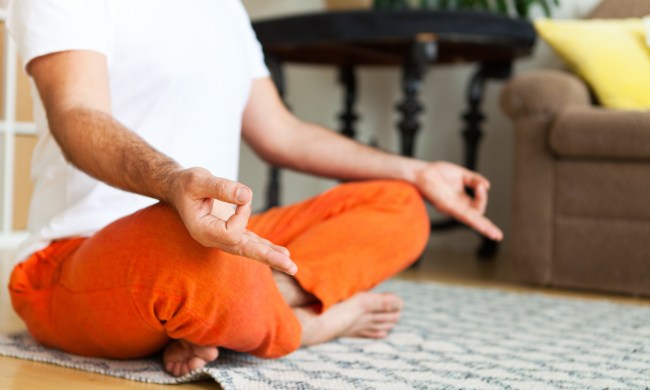 Man practicing yoga and meditation at home