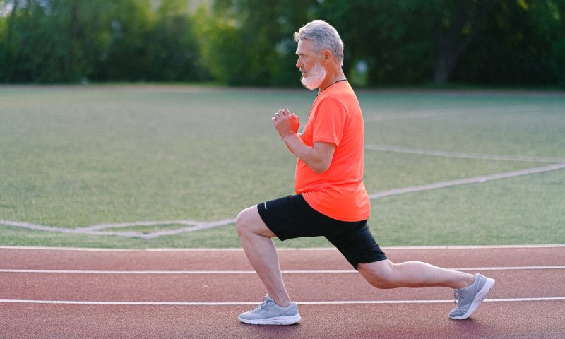 man lunging in workout older man