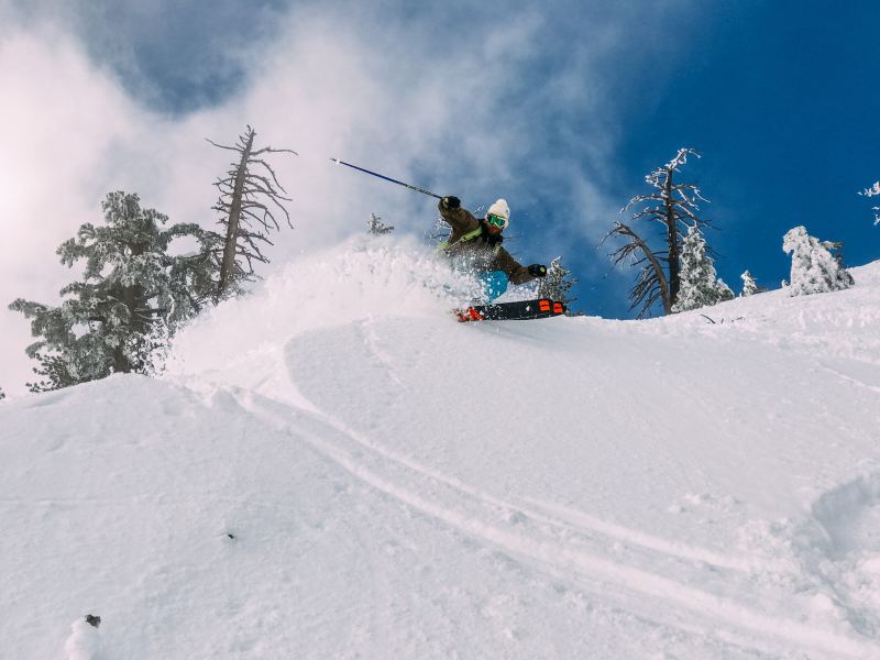 Skier spraying snow with skis