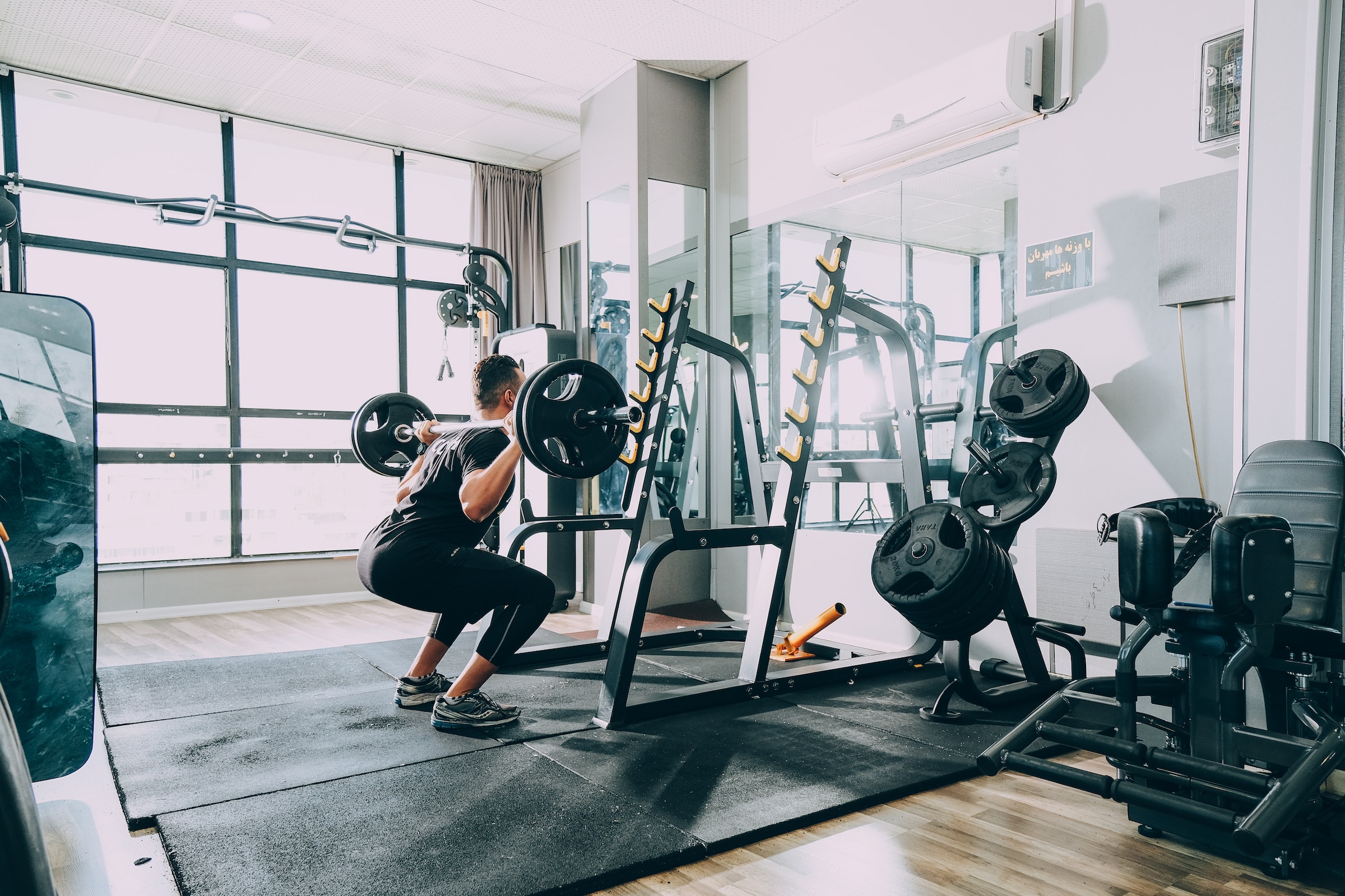 man crouching lifting weights strength resistance training at a gym