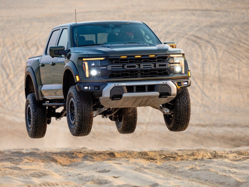 2024 Ford F-150 R airborne as it comes up a desert sand hill.