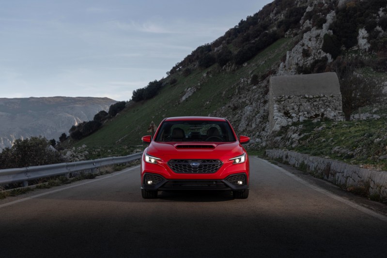 2024 Subaru WRX TR in red direct front view as the car drives on a mountain road.