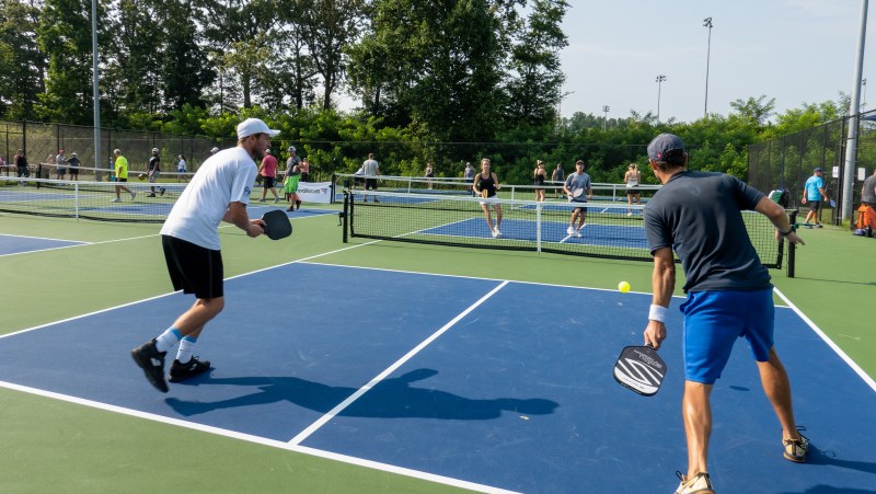 A group of pickleball players versing off.