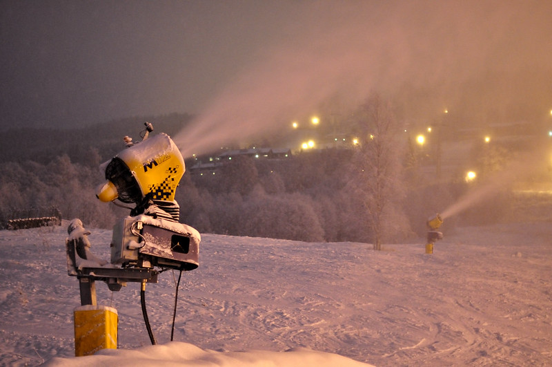 Snowmakers blowing snow at night