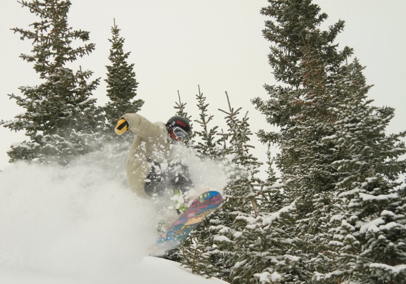 Snowboarder riding through the glades at Breckenridge