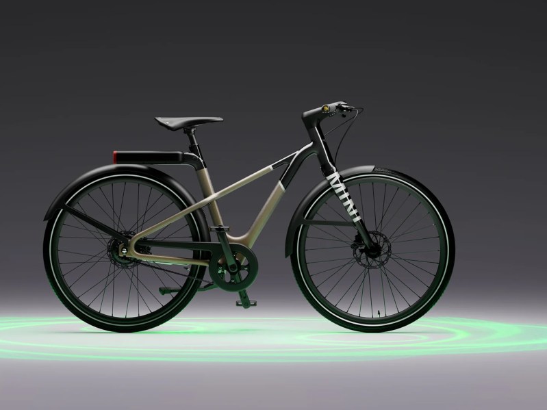 MINI E-Bike 1 Ocean Wave Green e-bike with a gray background with green light swirls.