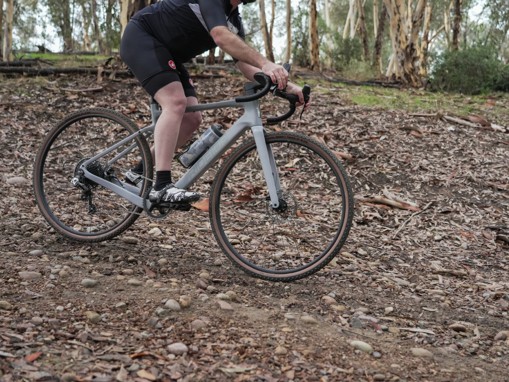 Ride1UP CF Racer1 with rider traversing a rocky hillside.