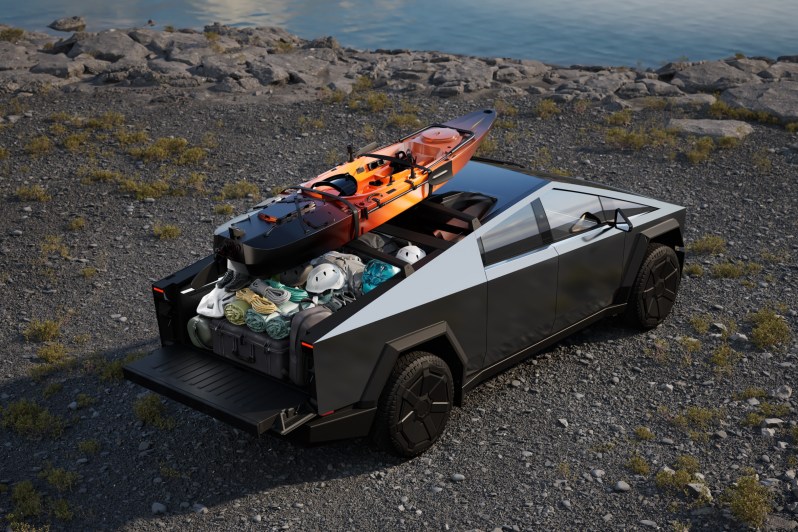 A Tesla Cybertruck with camping gear on the truck bed.