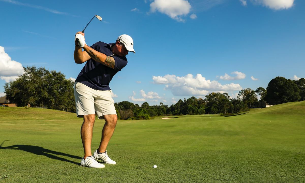 Someone about to take a swing at a golf ball.