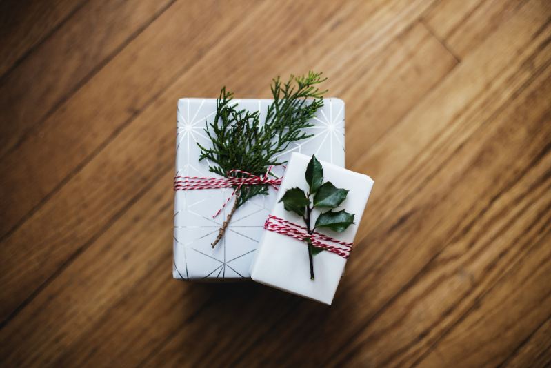 Gifts wrapped in white paper with foliage decoration