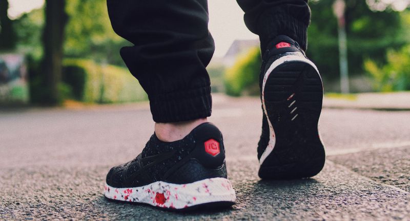 Person in black sneakers walking on the street