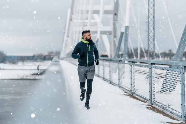 Man running across bridge in winter