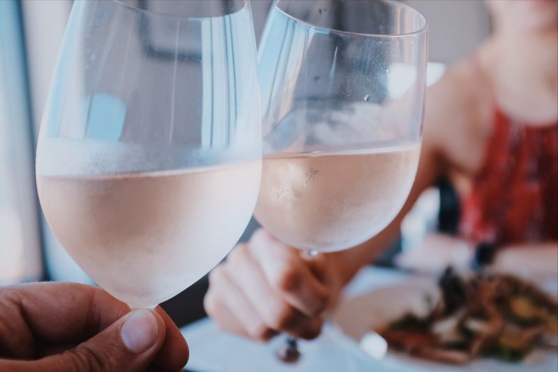 Hands toasting with two glasses of rose