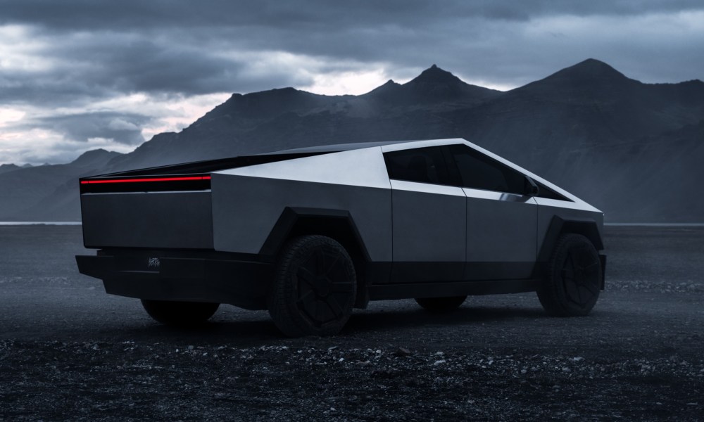 Tesla Cybertruck parked outside with a mountain in the background.