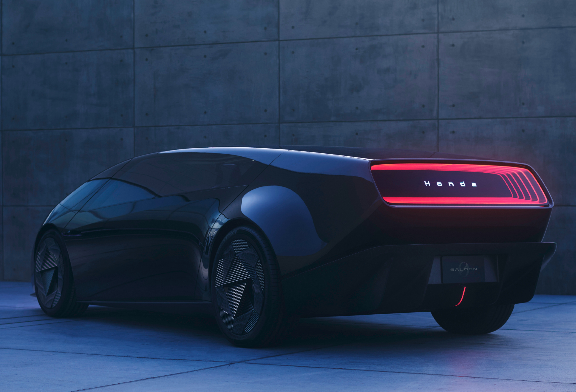 Honda 0 Saloon concept EV left side three-quarter rear showing rear lights with dark car turning toward a dark gray wall.