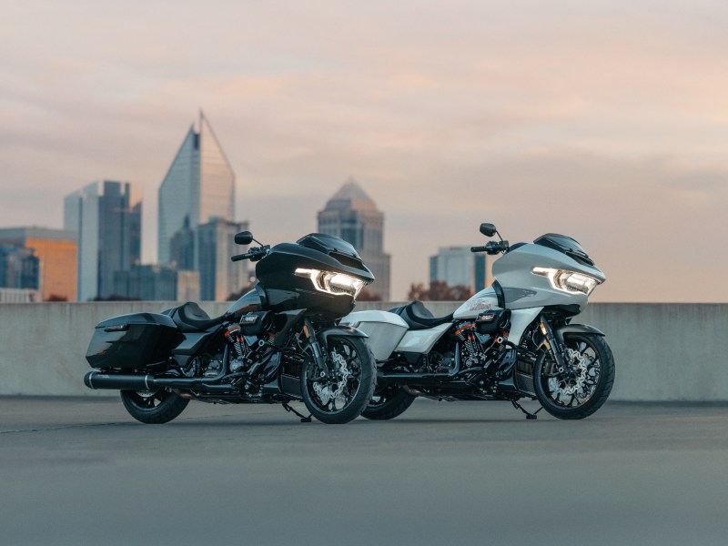 Two 2024 Harley-Davidson CVO Road Glide STs parked on a concrete deck overlooking a city.