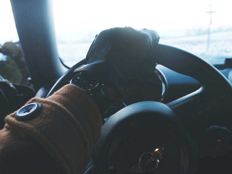 man wearing driving gloves and coat