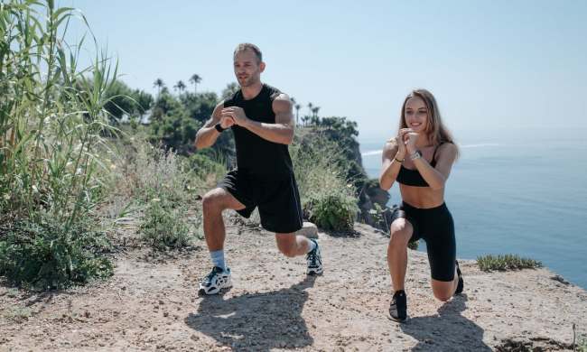 two people doing lunges outside