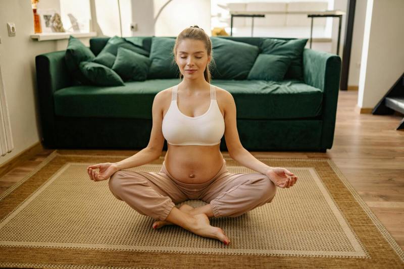 A pregnant woman is meditating.