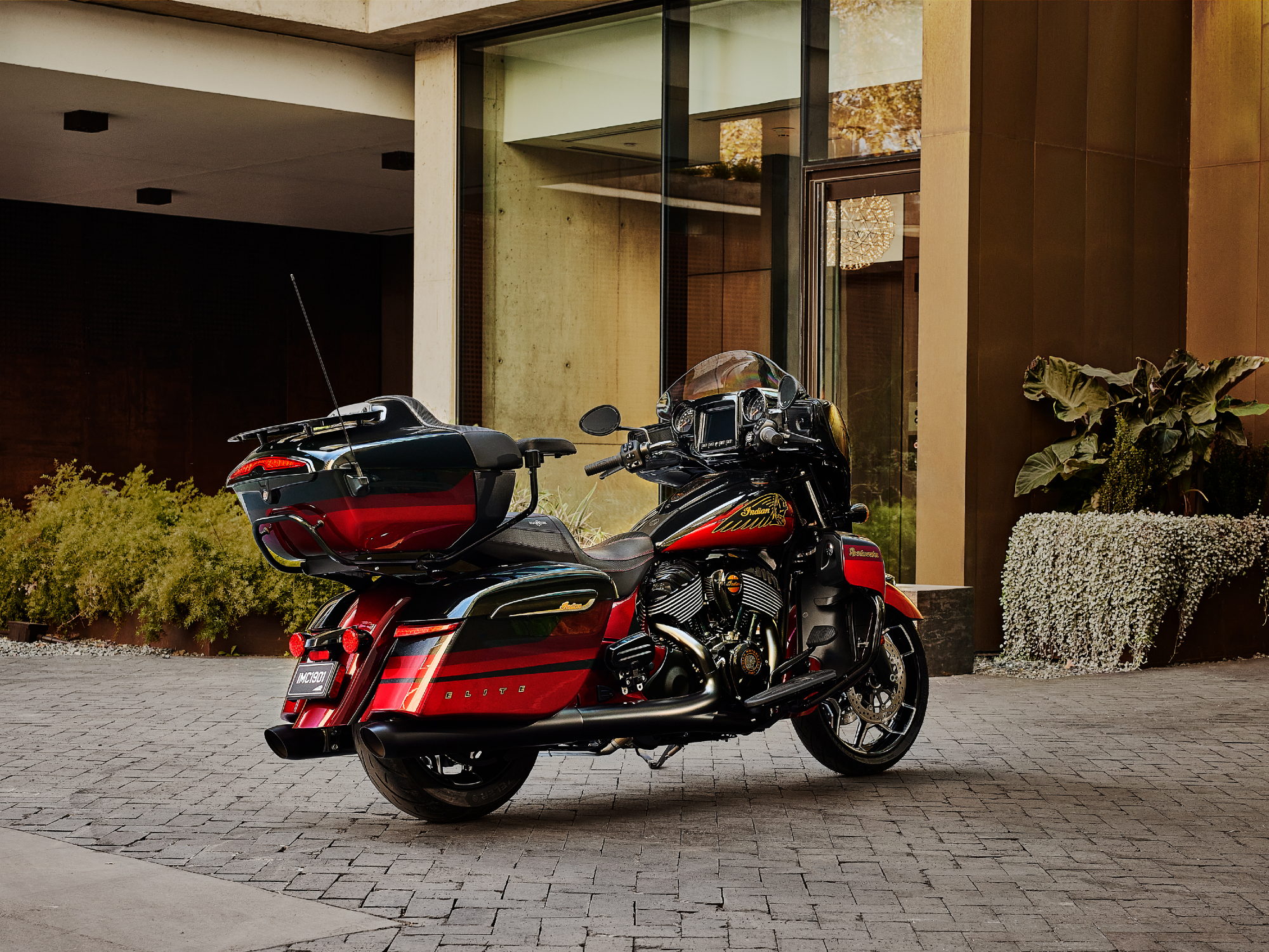 2024 Indian Roadmaster Elite right rear three-quarter view parked in front of a modern apartment or office building entrance.