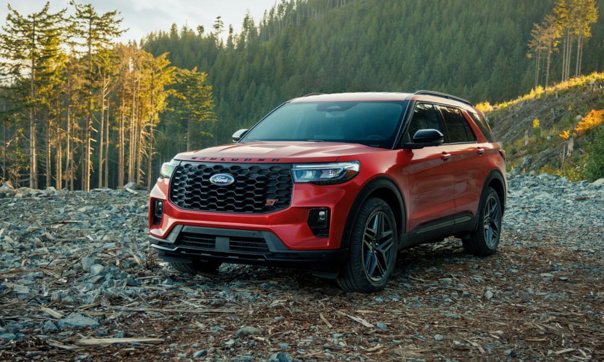 2025 Ford Explorer ST parked on loose rock with forested hills in the background.