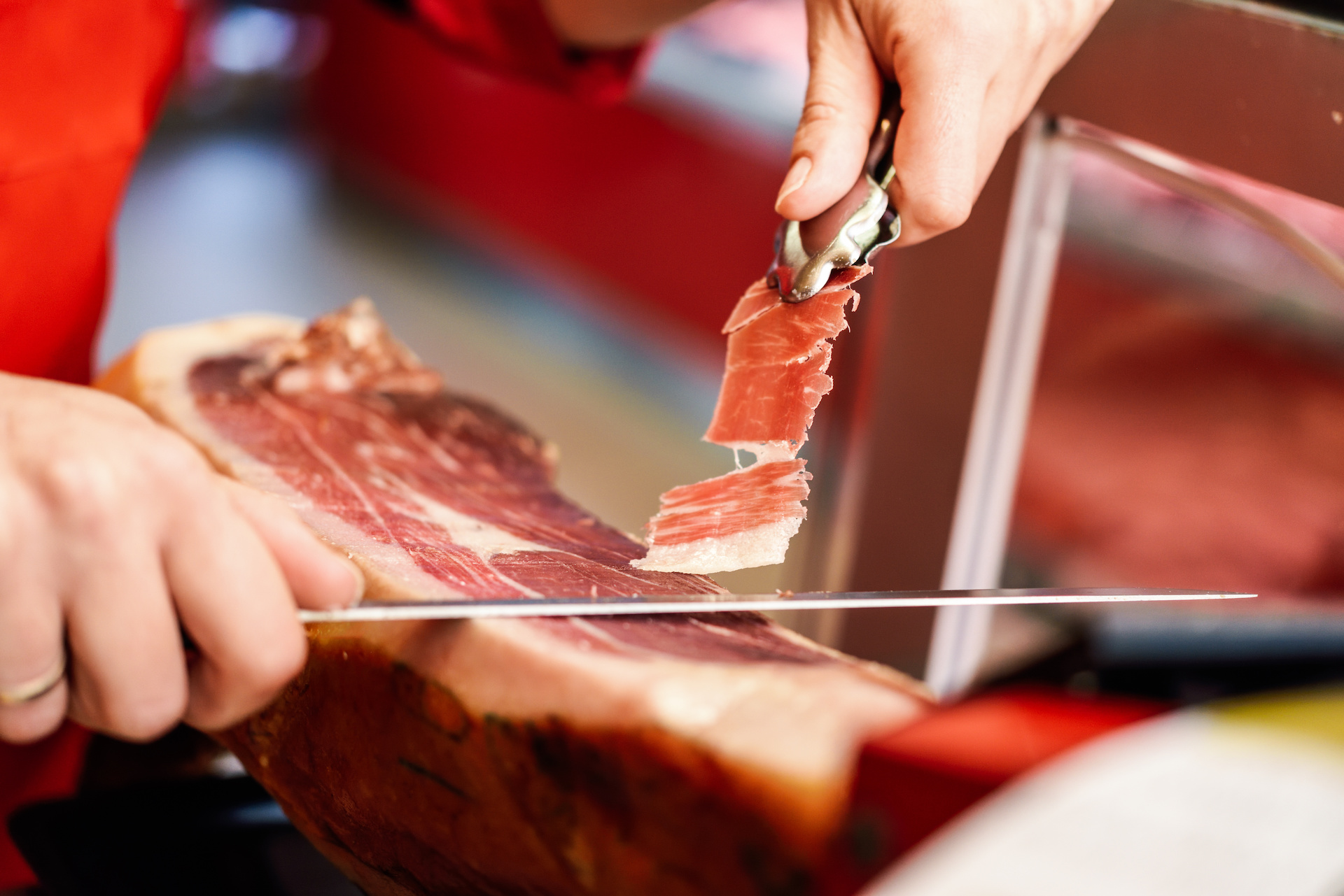 Person carving prosciutto