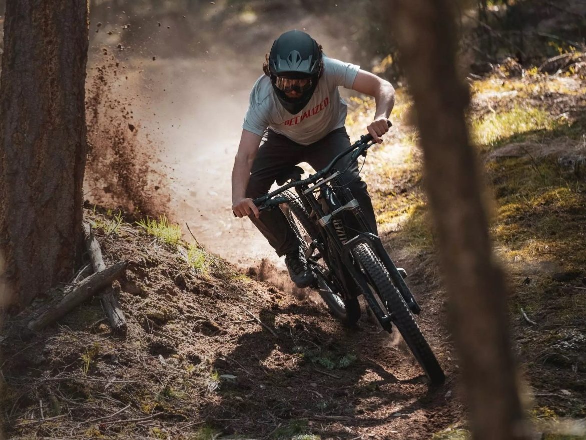 A man riding a Specialized mountain bike down a difficult trail.