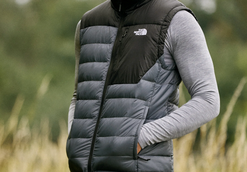 Wearing a North Face vest in a field.