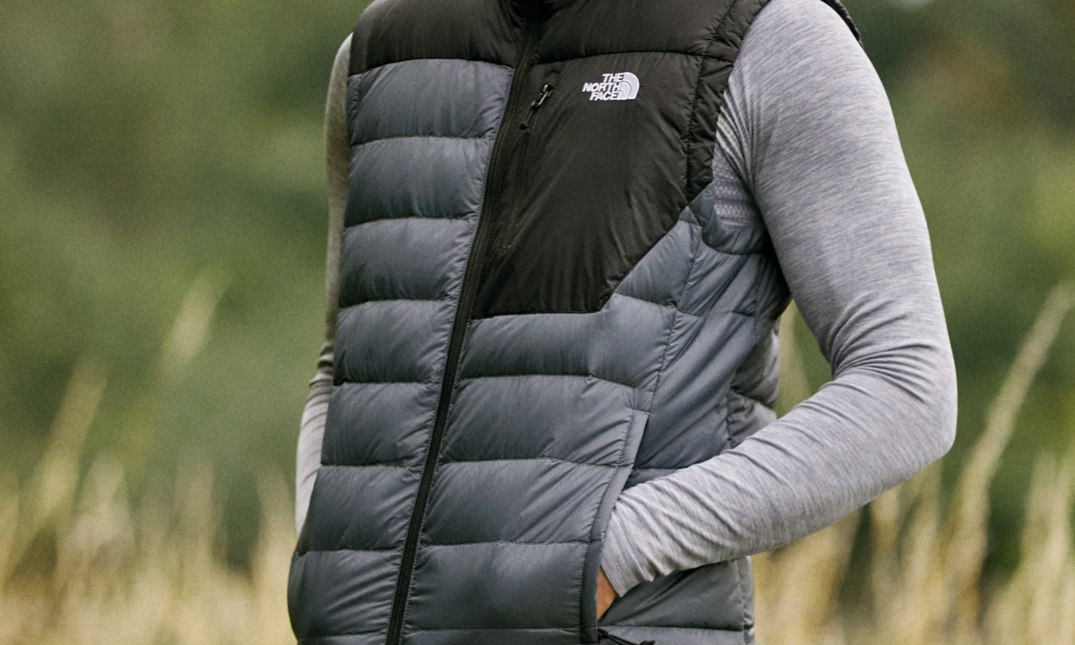Wearing a North Face vest in a field.