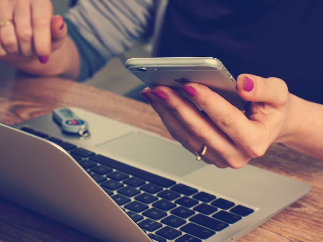 Woman looking at cell phone with network issues -- is AT&T down