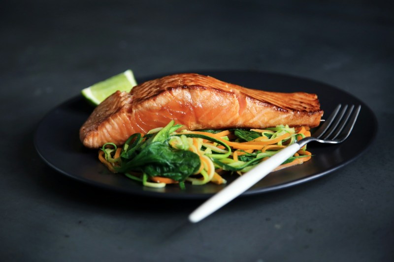 Salmón y ensalada en un plato negro