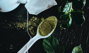 green tea leaves in spoon and bag