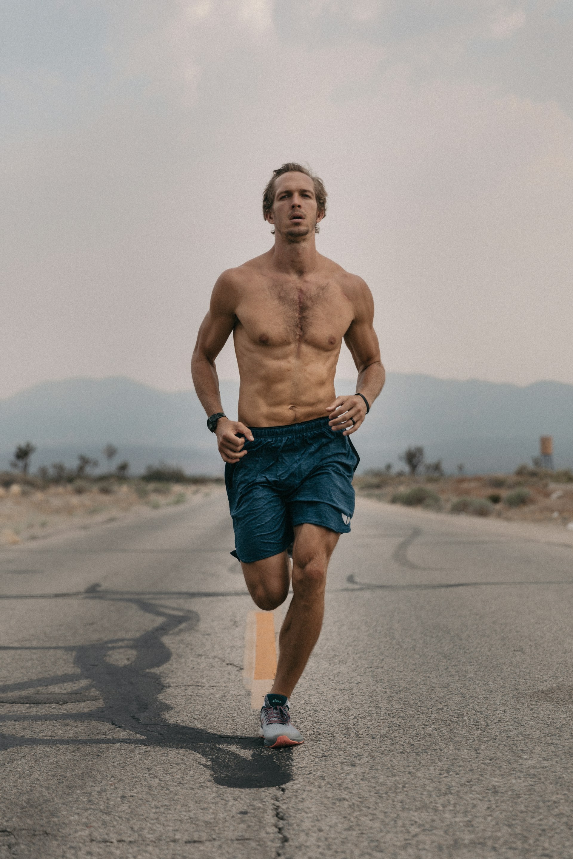 man running in shorts outside on the road