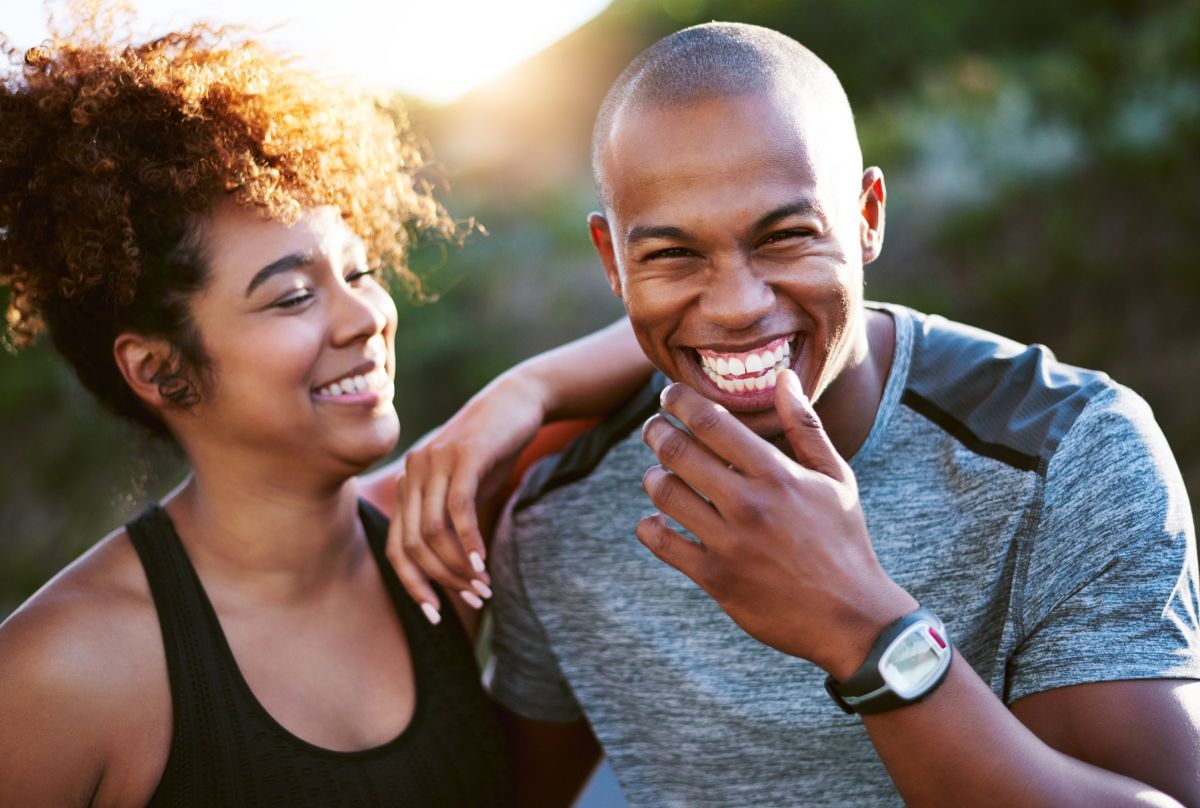 A man and woman laughing after a workout