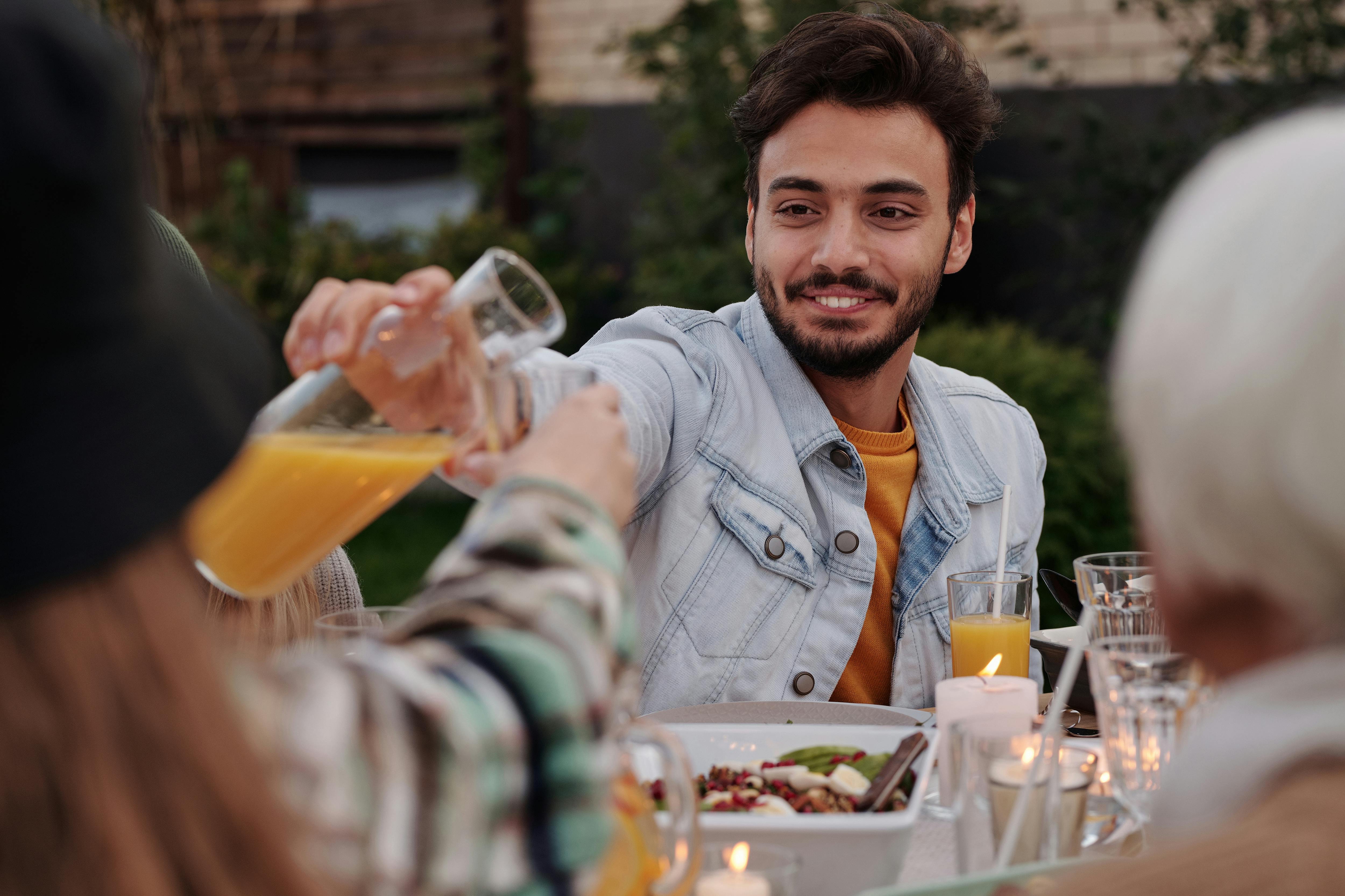 Man sharing a meal with friends at a table