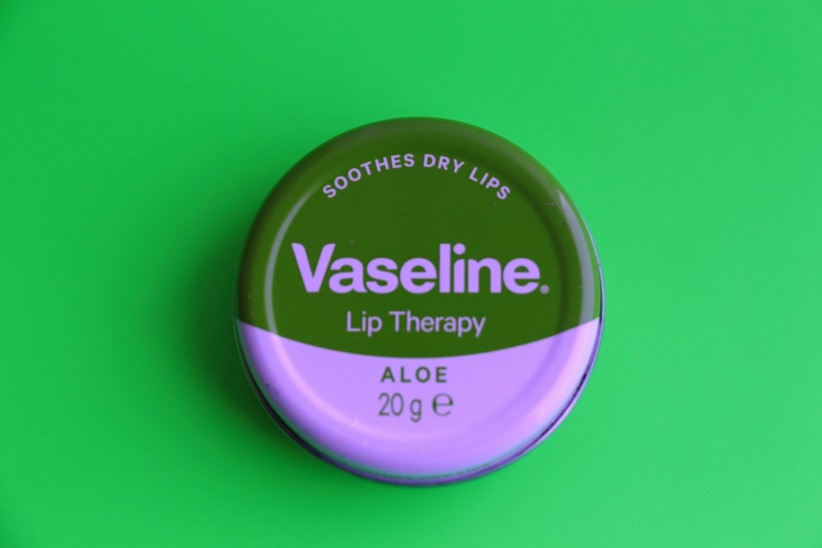 a vaseline lip product on a greenscreen backdrop