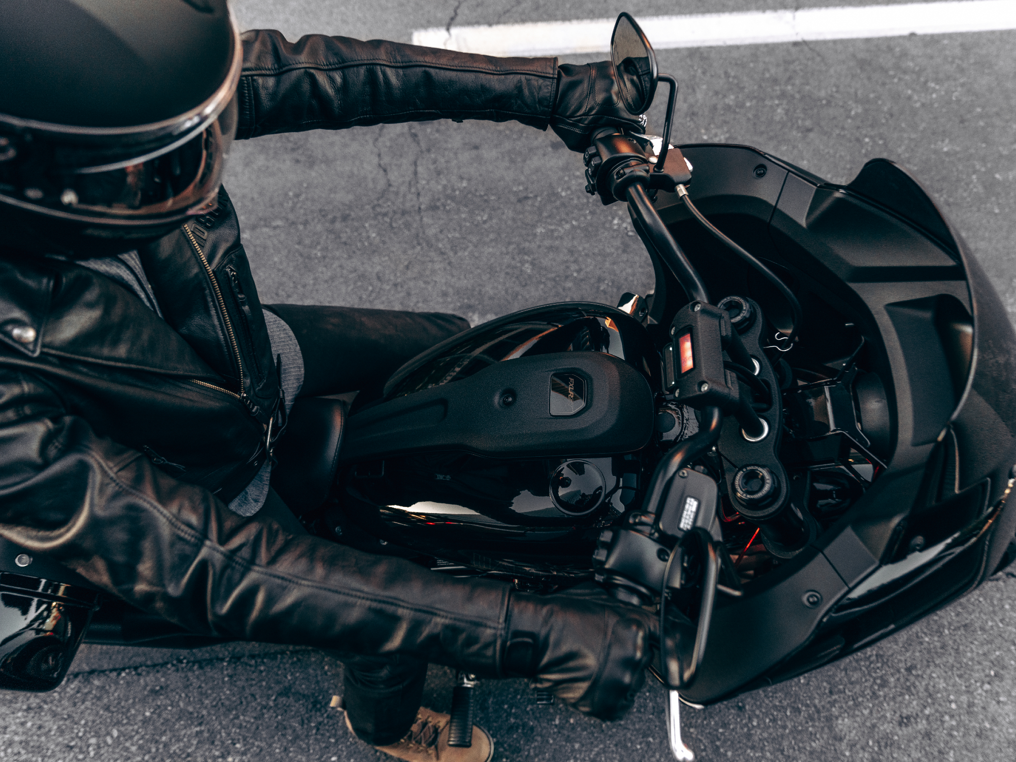 2024 Harley-Davidson Low Rider ST in Vivid Black color with rider looking down on driver cockpit.