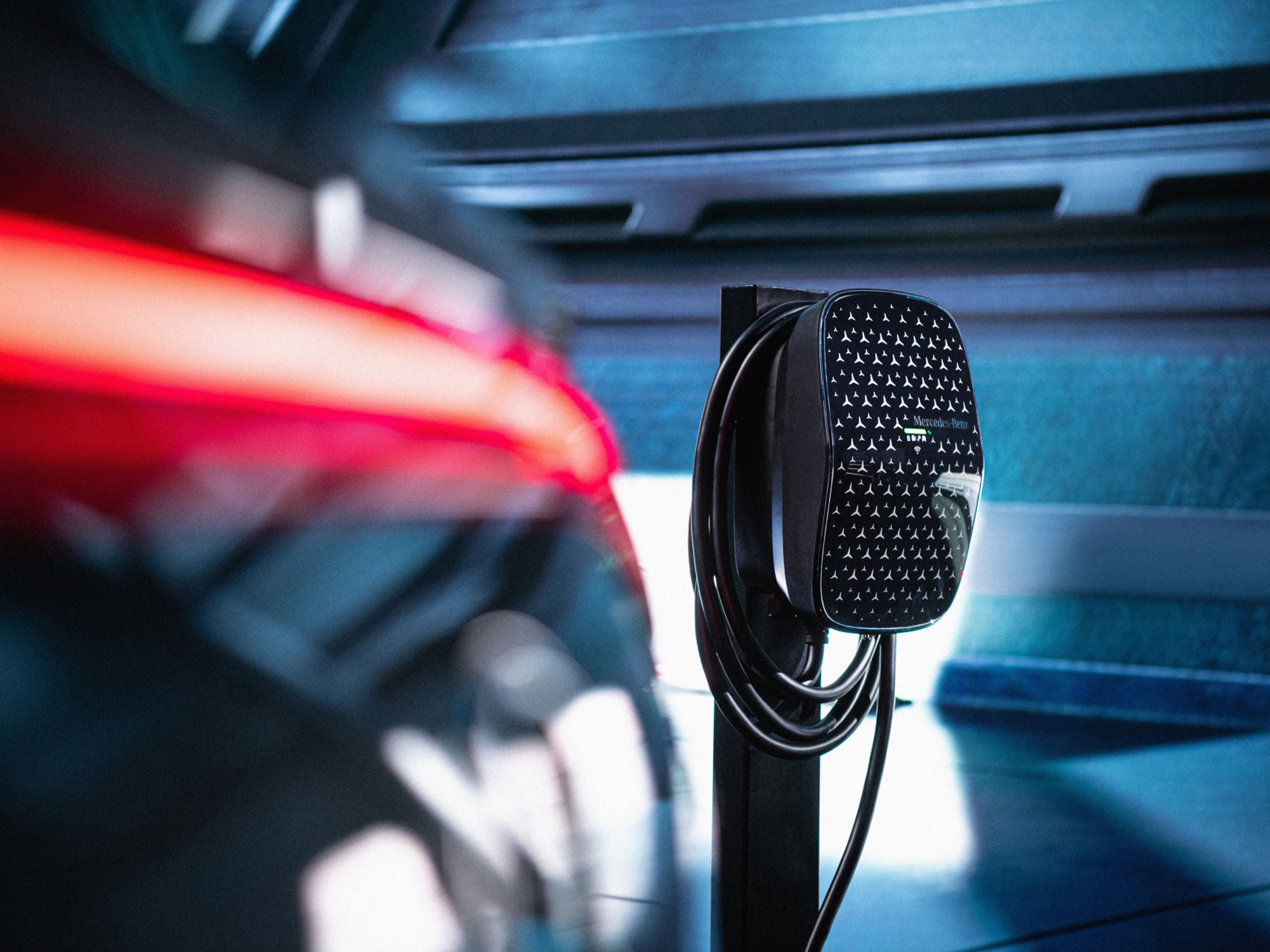 Mercedes-Benz Wallbox home EV charger in a garage behind a car with its taillights on.