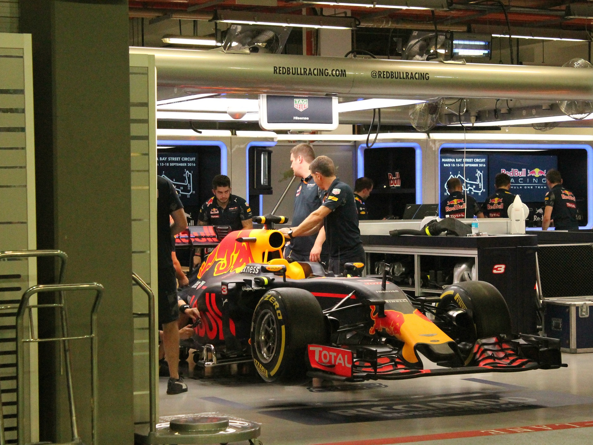 Miembros del equipo de boxes de Red Bull F1 y mecánicos en el garaje con el coche de carreras de F1.