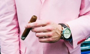 Man in pink suit smoking and enjoying what a cigar tastes like.